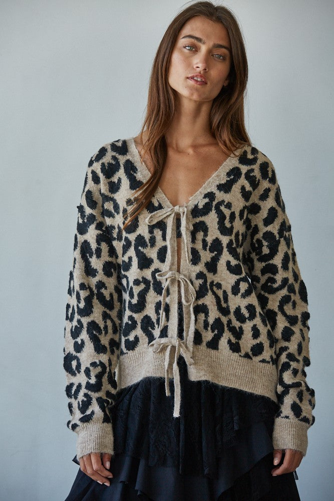 Woman wearing  Feline Leopard Print Tie Cardigan in mocha black showing leopard knit pattern and tie-front closure (Front view)