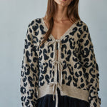 Woman wearing  Feline Leopard Print Tie Cardigan in mocha black showing leopard knit pattern and tie-front closure (Front view)