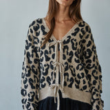 Woman wearing  Feline Leopard Print Tie Cardigan in mocha black showing leopard knit pattern and tie-front closure (Front view)