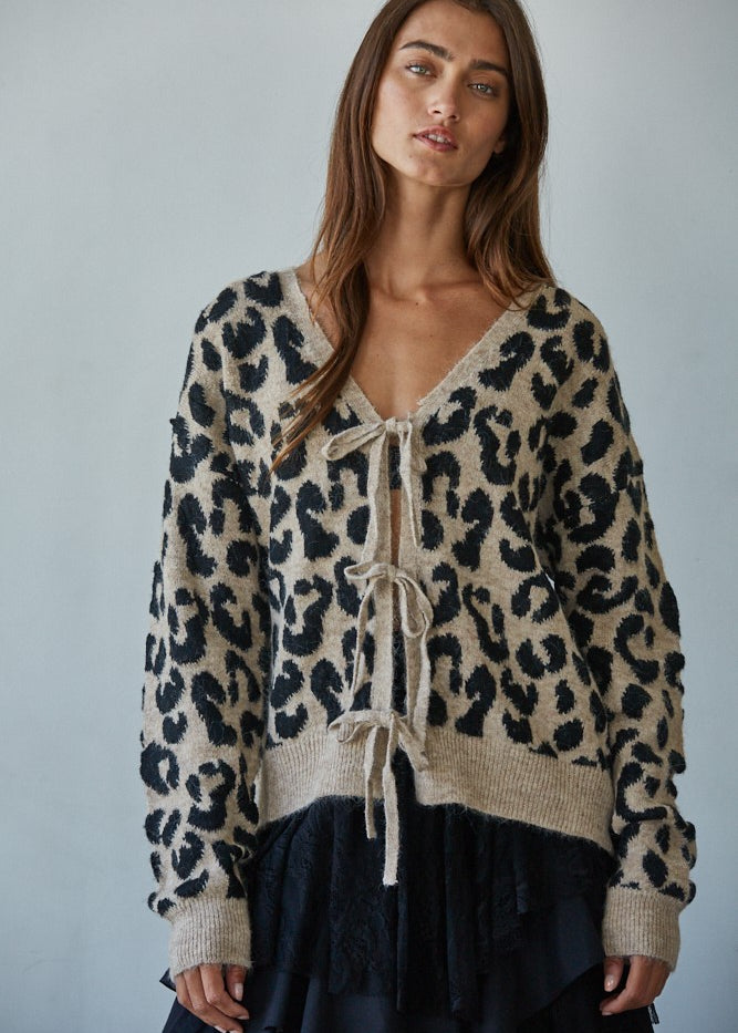 Woman wearing  Feline Leopard Print Tie Cardigan in mocha black showing leopard knit pattern and tie-front closure (Front view)