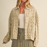 Styled front view of the Floral Back-Pleated Cotton Jacket in taupe layered over a dress