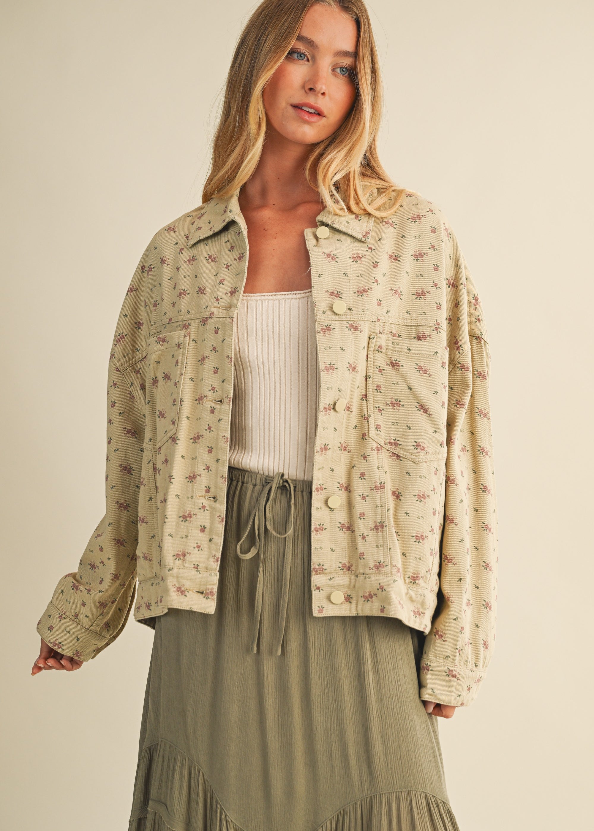 Styled front view of the Floral Back-Pleated Cotton Jacket in taupe layered over a dress