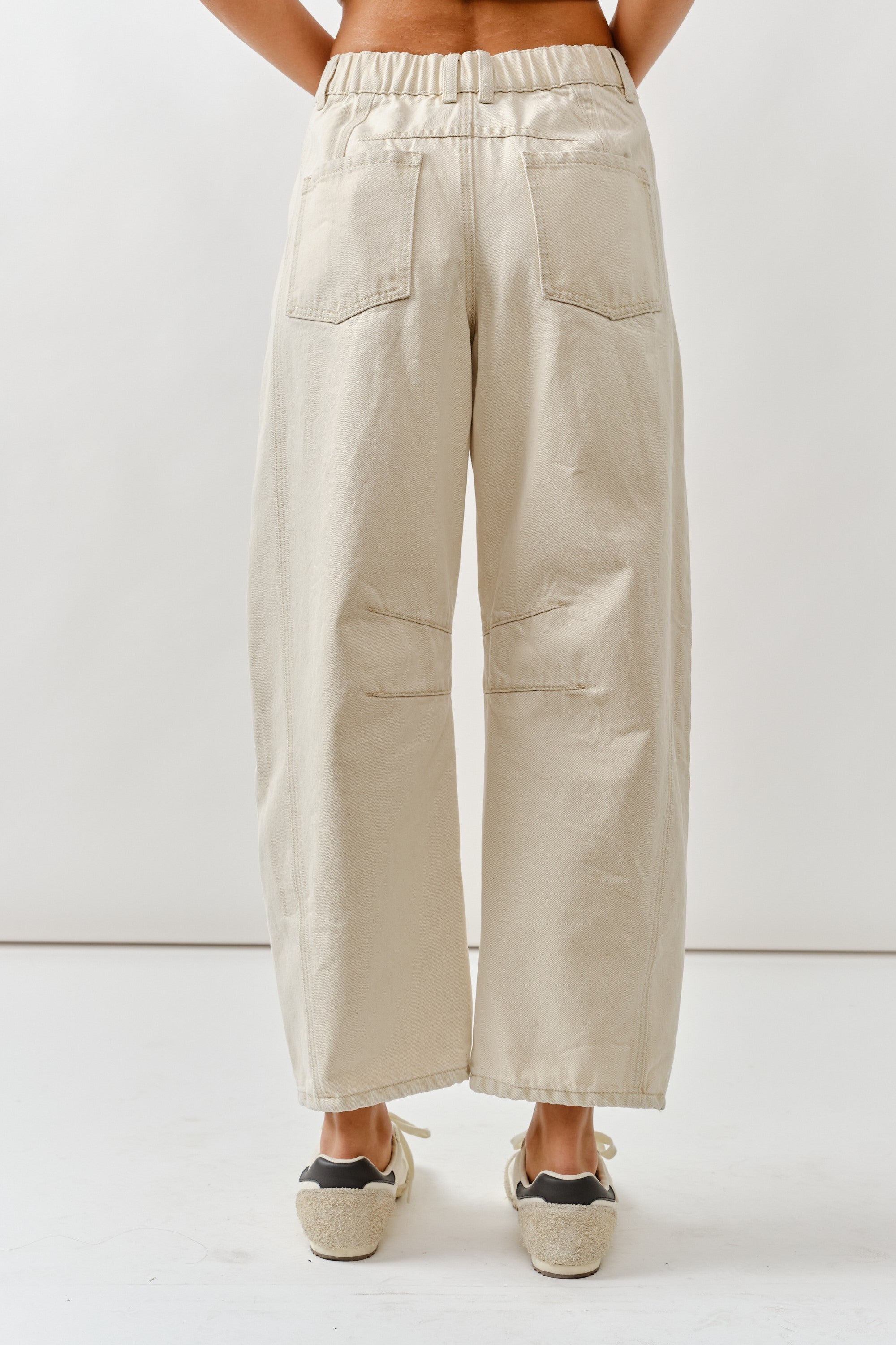 Beige wide-leg pants worn by a person on a white background