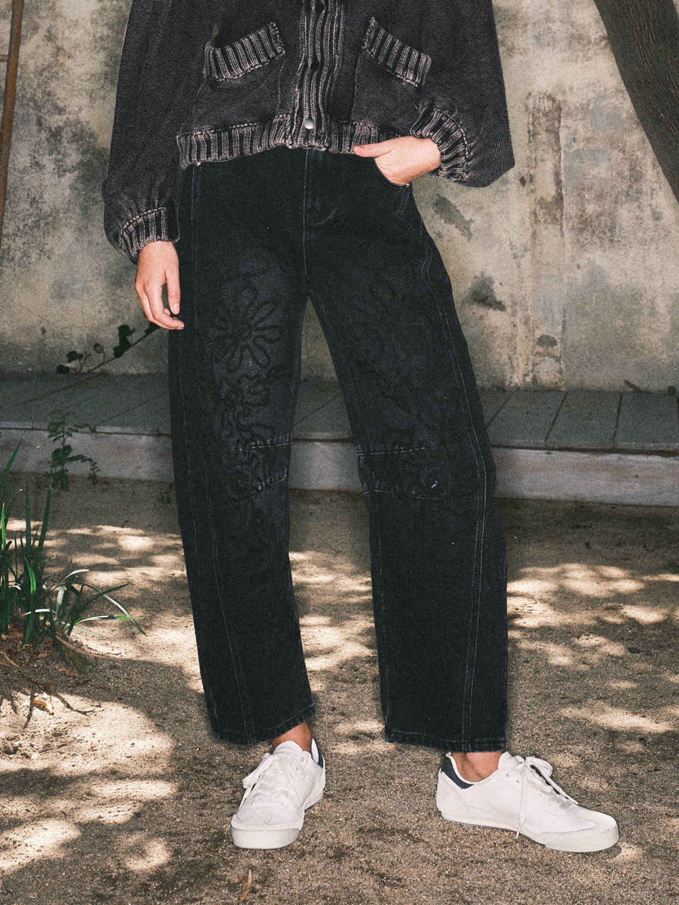 Front lifestyle view of model wearing Floral Embroidered Barrel Leg Jeans in faded black