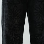 Close-up detail of the barrel-leg shape and faded black denim texture