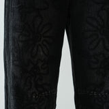 Close-up detail of the barrel-leg shape and faded black denim texture