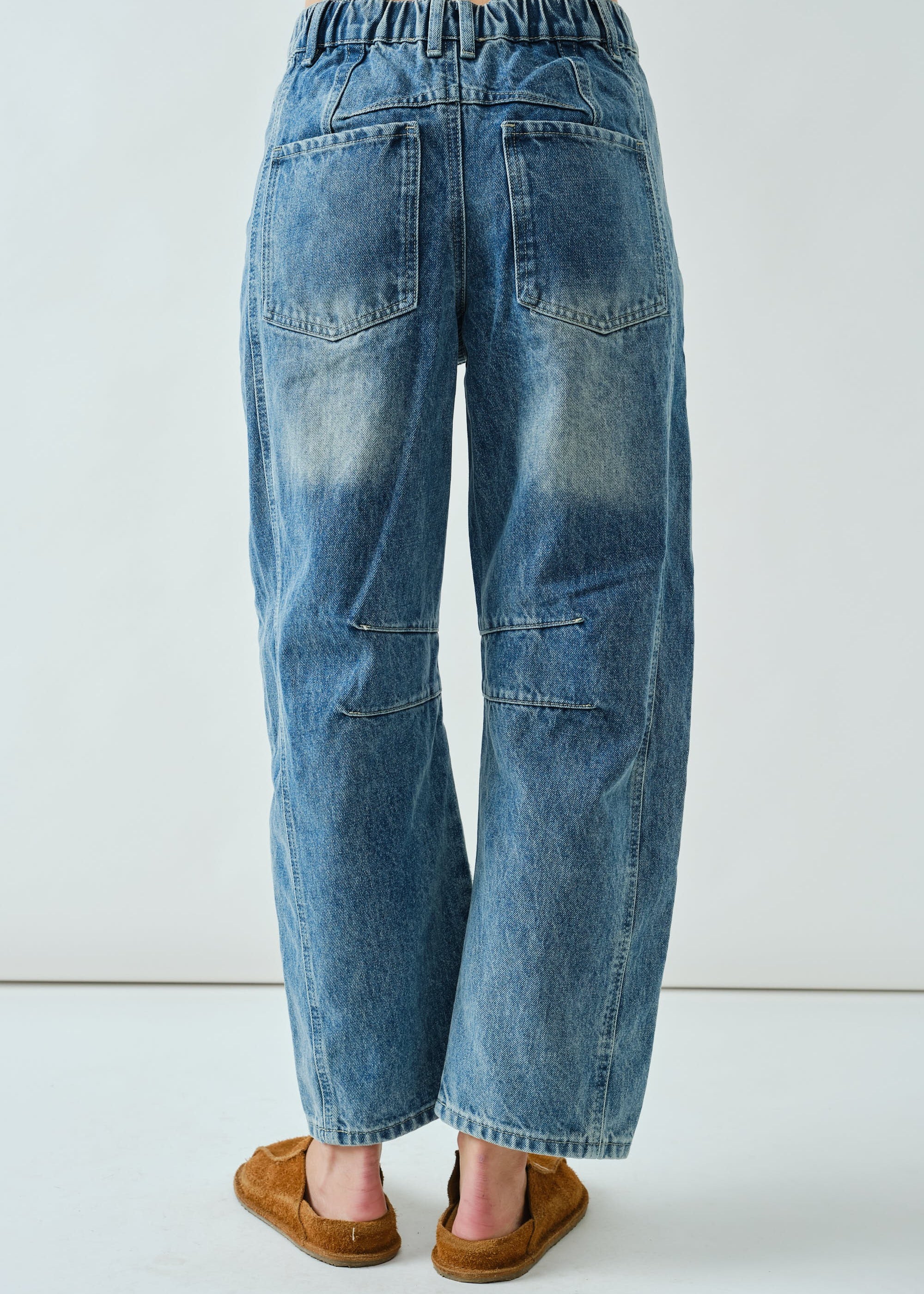 Back view of the medium wash embroidered barrel-leg jeans
