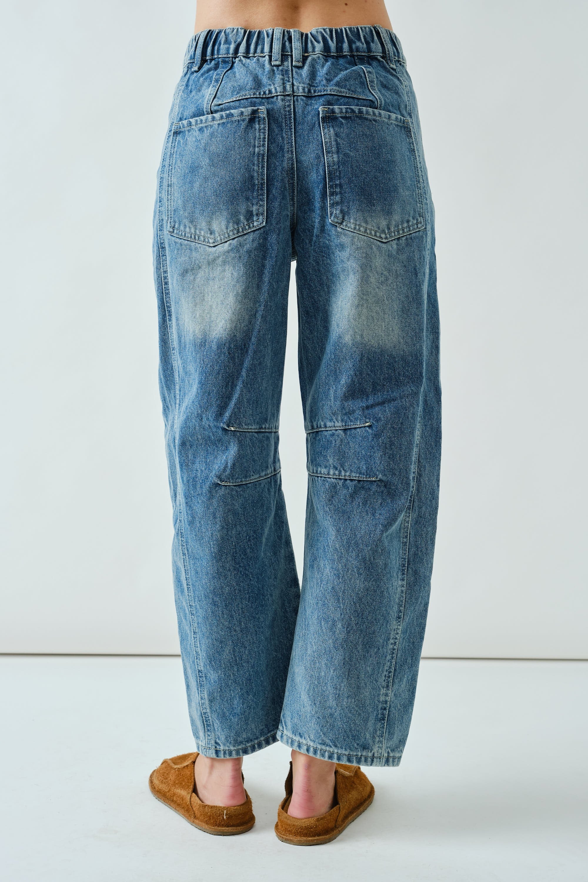 Back view of the medium wash embroidered barrel-leg jeans