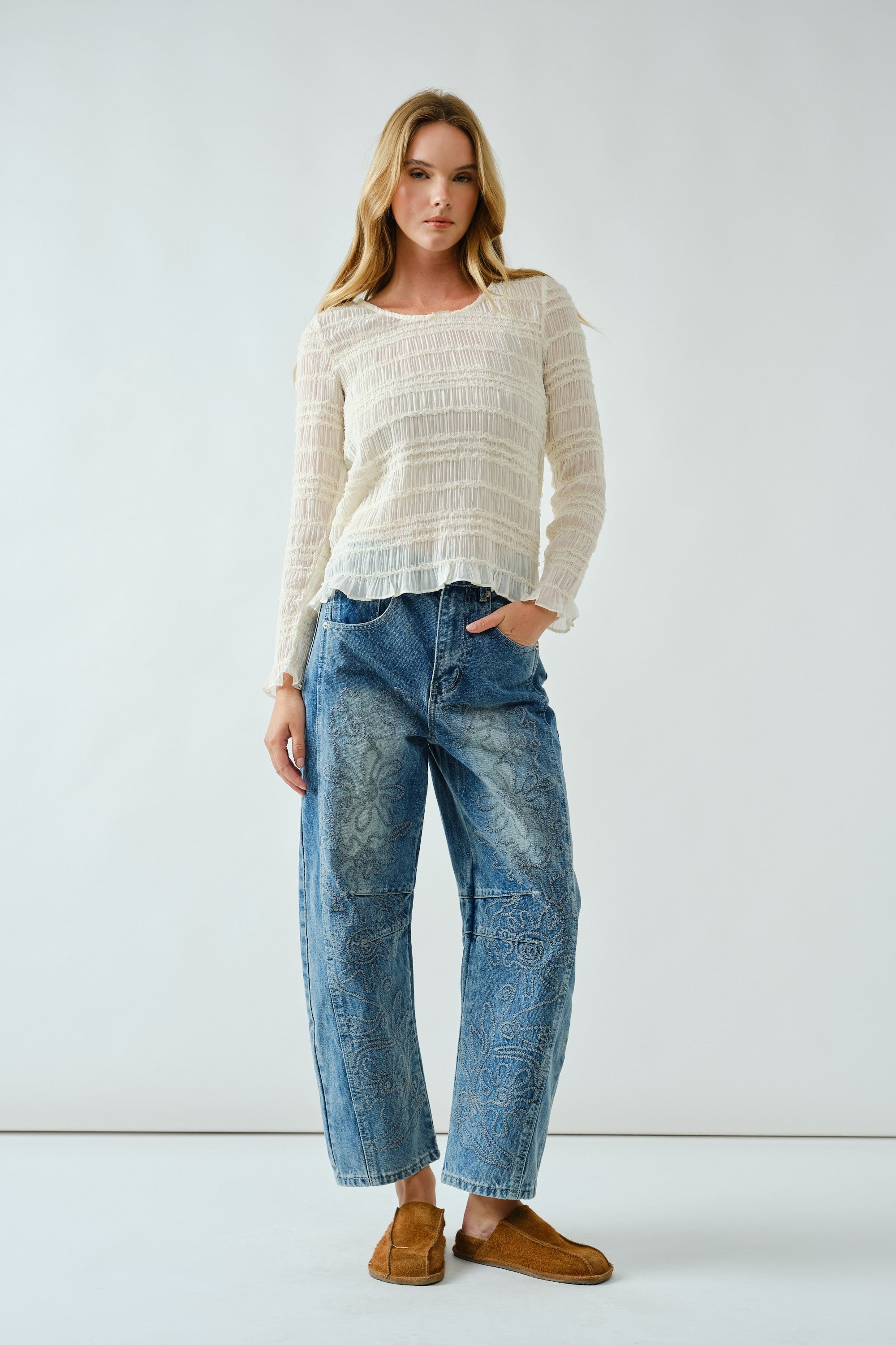 Front portrait of model wearing Floral Embroidered Barrel Leg Jeans in medium wash