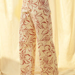 Side view of red floral print wide leg denim pants with high-rise fit