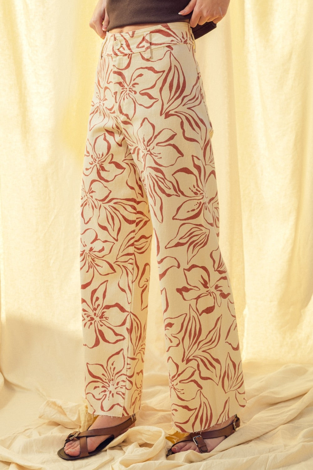 Side view of red floral print wide leg denim pants with high-rise fit