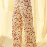 Side view of red floral print wide leg denim pants with high-rise fit