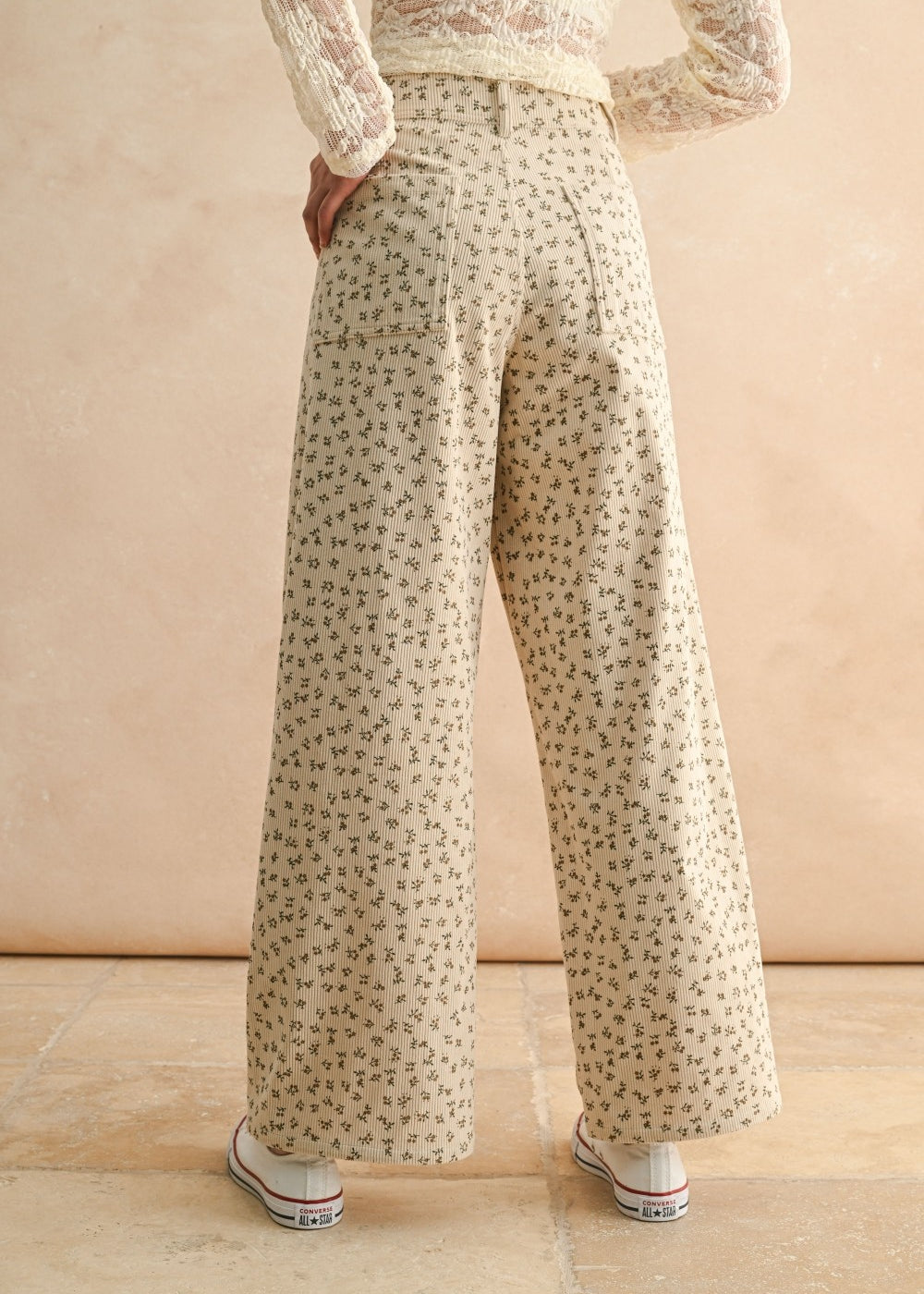 Back view of floral wide leg corduroy pants in tan and olive with back pockets