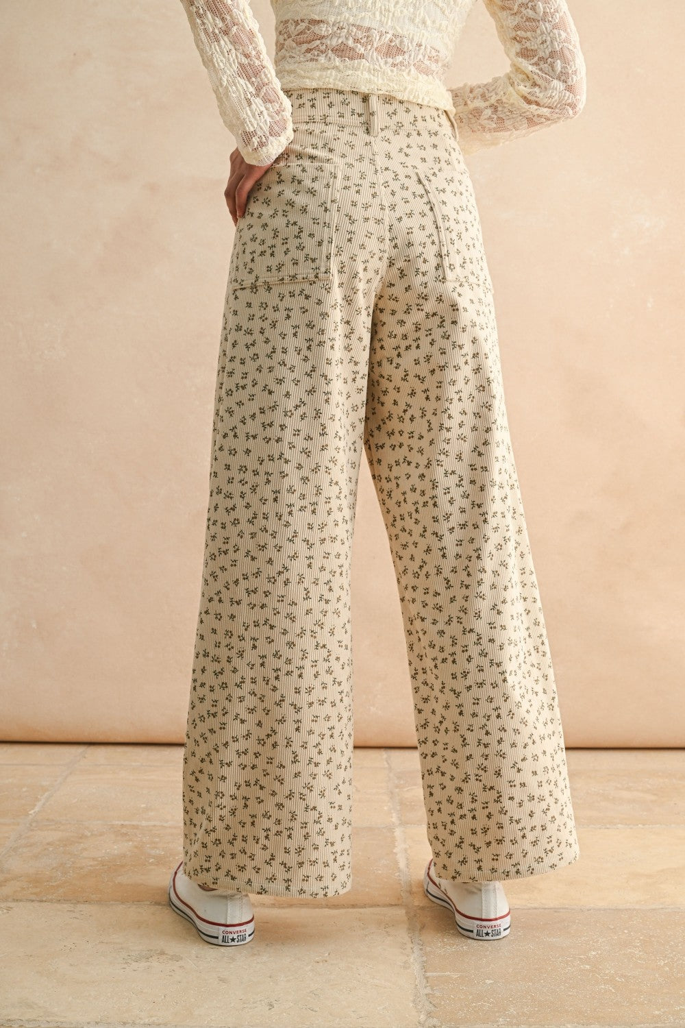 Back view of floral wide leg corduroy pants in tan and olive with back pockets