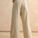 Back view of floral wide leg corduroy pants in tan and olive with back pockets