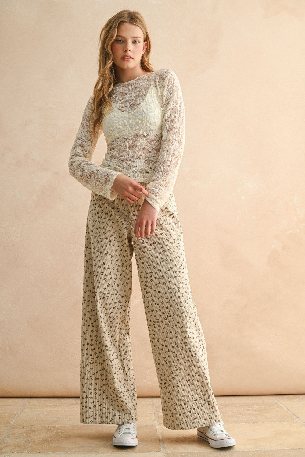 Woman wearing tan and olive floral wide leg corduroy pants styled with casual outfit