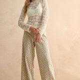 Woman wearing tan and olive floral wide leg corduroy pants styled with casual outfit