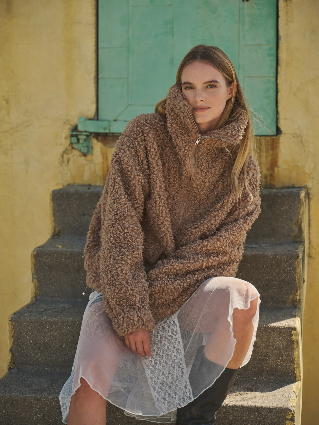 Woman wearing a taupe half-zip teddy fleece jacket outdoors