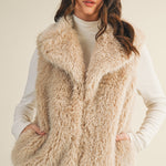 Styled front view of the faux fur vest layered over a knit top