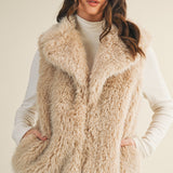 Styled front view of the faux fur vest layered over a knit top