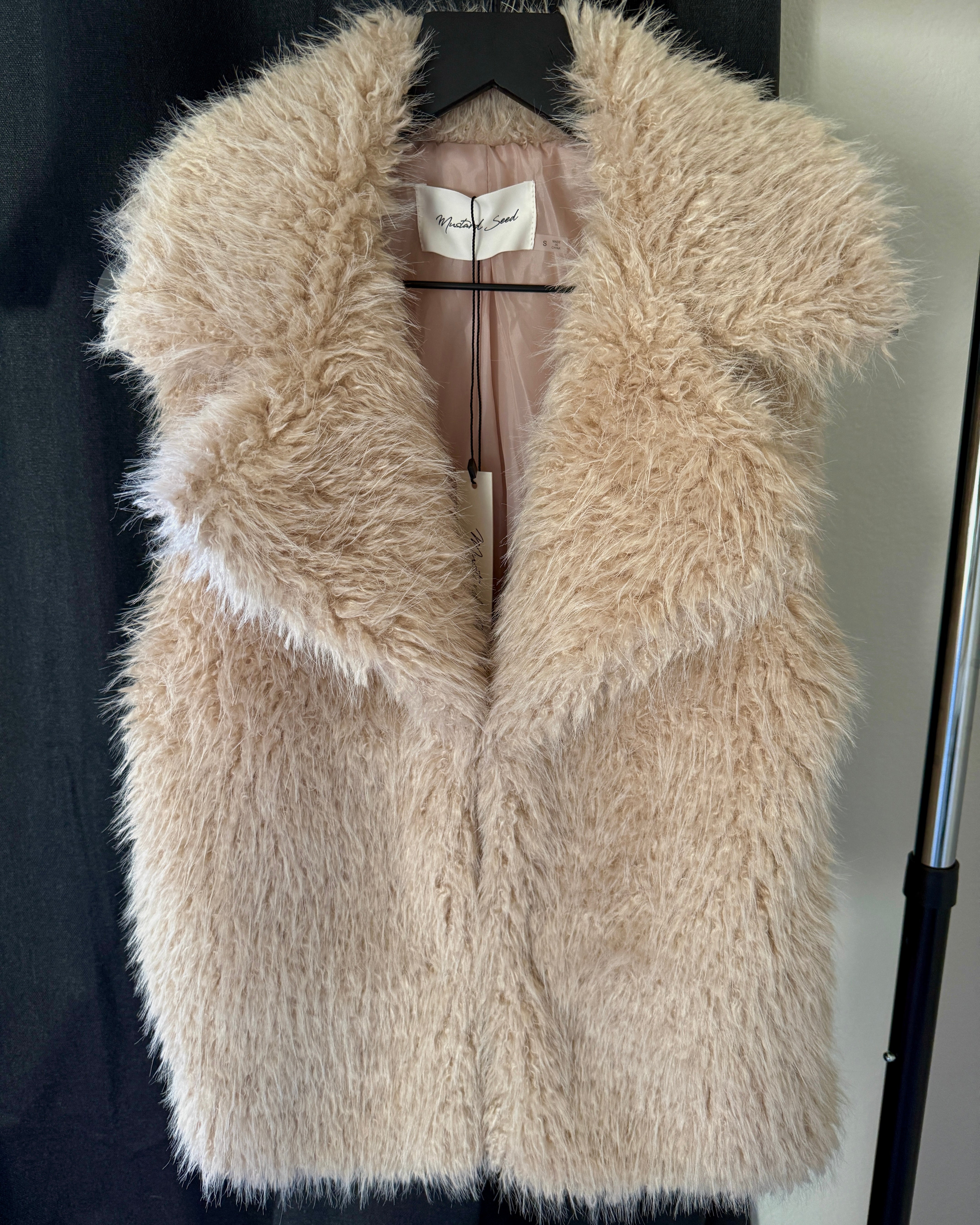 Close-up detail of the soft faux fur texture on the Fuzzy Dream Vest displayed on a hanger, with no model shown