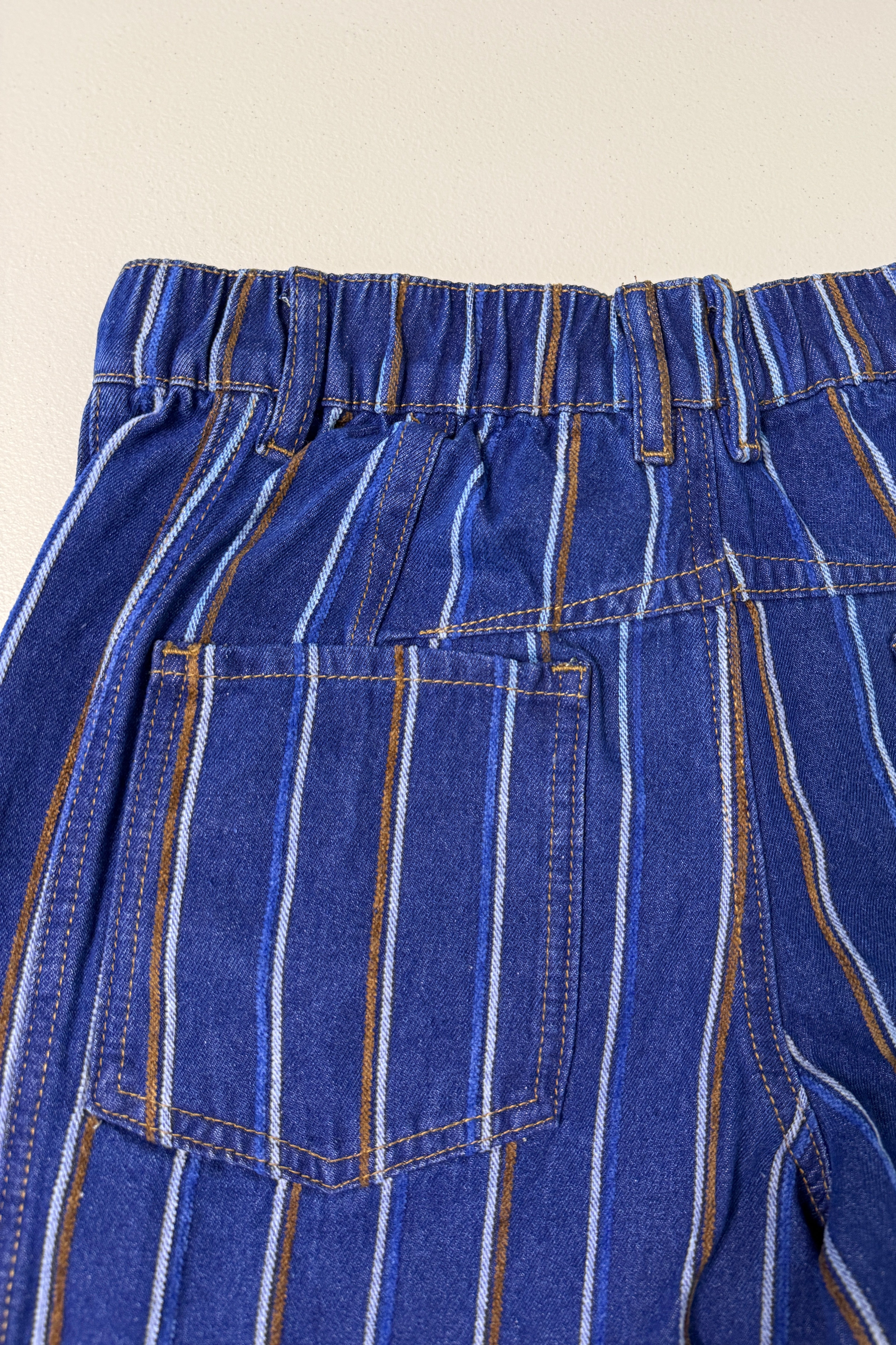Close-up detail of Good Luck Barrel Jeans showing navy denim, brushed white and brown stripes, bck pockets