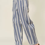 Blue and white striped pants worn by a person on a plain background