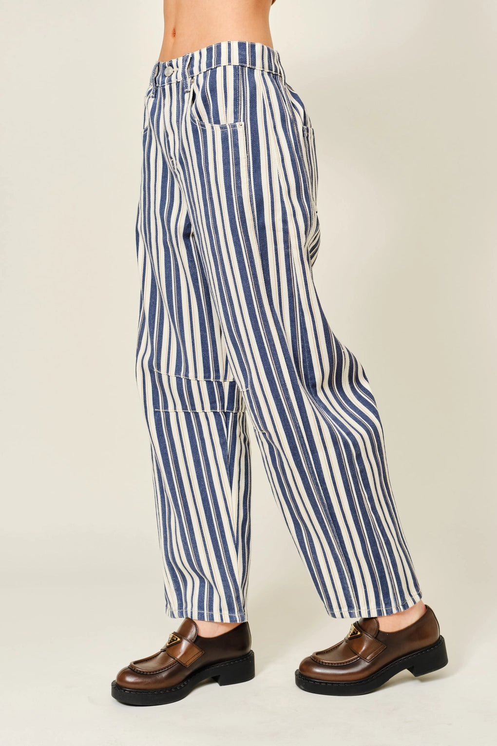 Blue and white striped pants worn by a person on a plain background