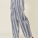 Blue and white striped pants worn by a person on a plain background