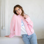 Woman wearing Hailey button down cardigan in baby pink for everyday style