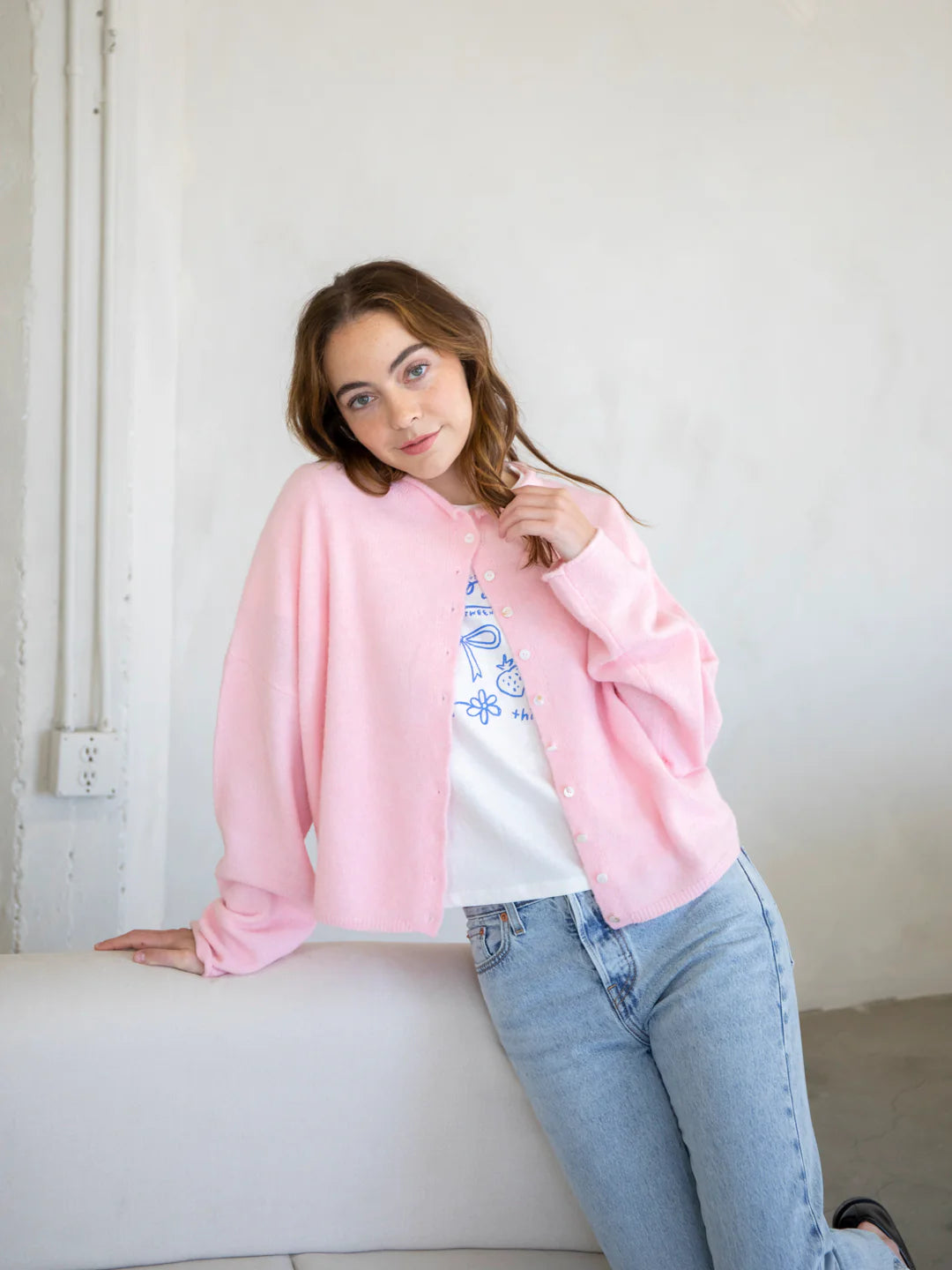 Woman wearing Hailey button down cardigan in baby pink for everyday style