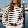 Model wearing the Things Between Piper Cardigan Cabana Stripe Cream Brown at a marina - lifestyle view