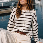 Model wearing the Hailey Button Down Cardigan in Cabana Stripe Cream-Brown in a sitting lifestyle pose