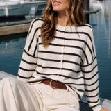 Model wearing the Hailey Button Down Cardigan in Cabana Stripe Cream-Brown in a sitting lifestyle pose