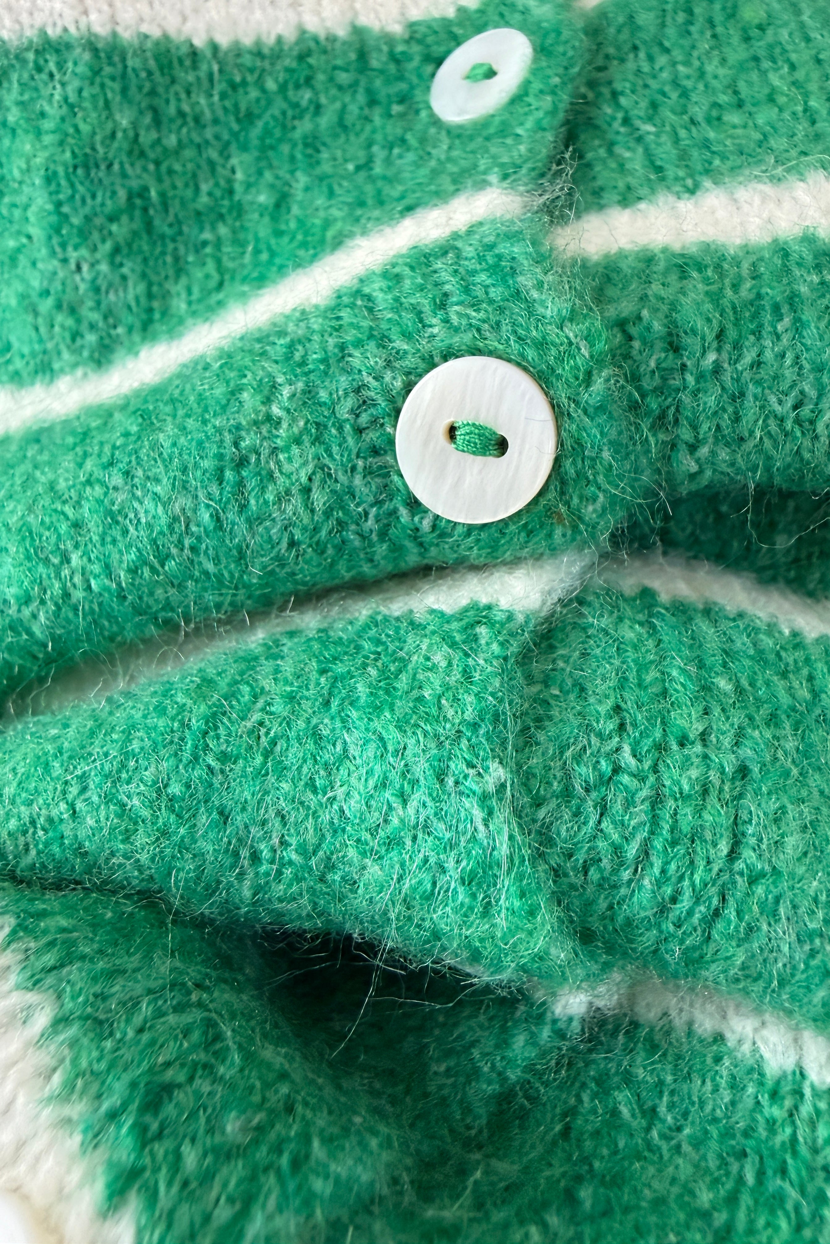 Close-up of Hailey button down cardigan in Kelly green cabana stripe with button detail