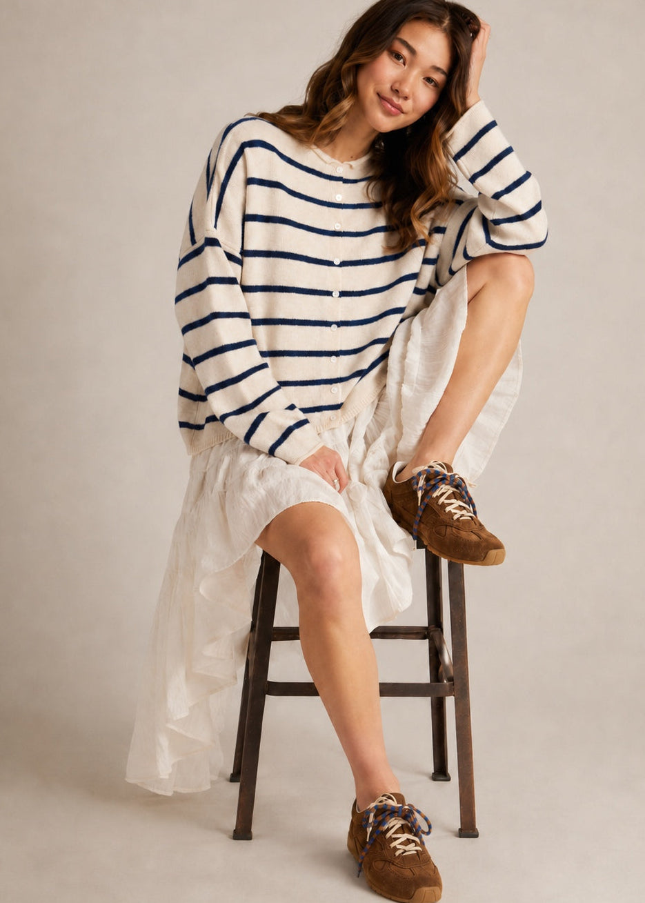 Model wearing the Things Between Piper Cardigan Cabana Stripe Natural Navy in a full outfit sitting pose