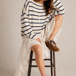 Model wearing the Hailey Button Down Cardigan in Cabana Stripe Natural-Navy in a full outfit sitting pose