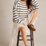 Model wearing the Hailey Button Down Cardigan in Cabana Stripe Natural-Navy in a full outfit sitting pose