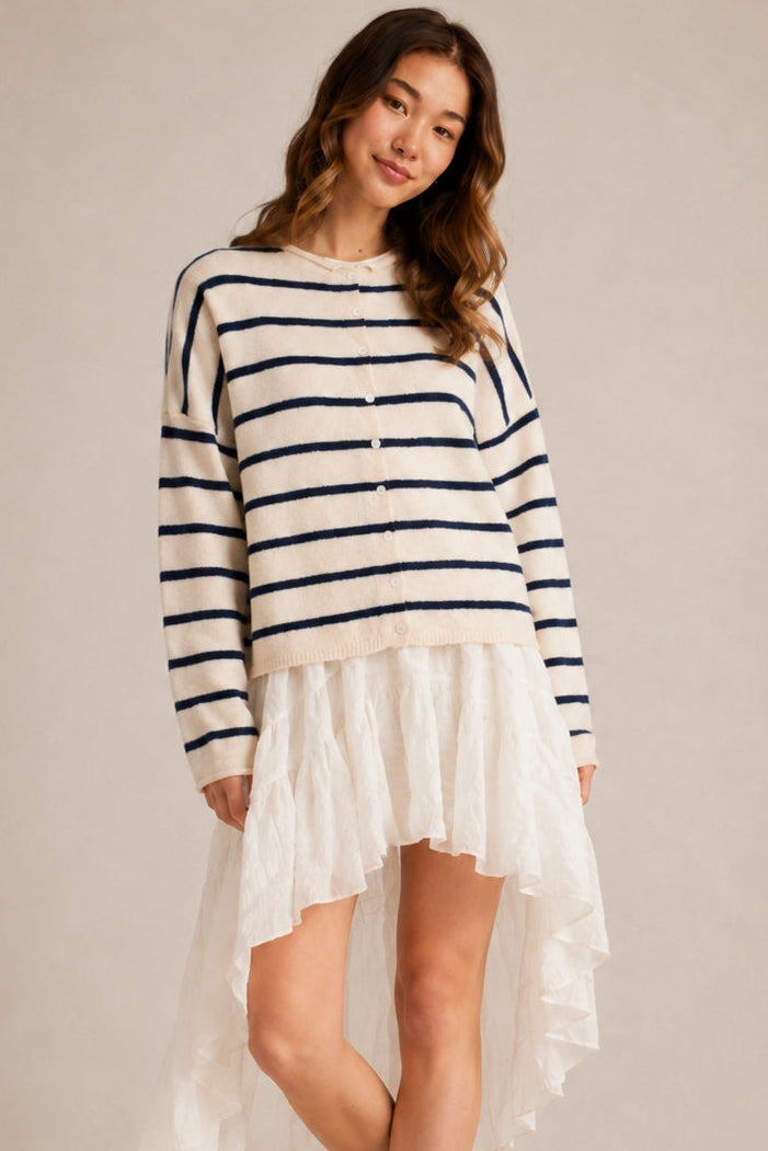 Model wearing the Hailey Button Down Cardigan in Cabana Stripe Natural-Navy in a relaxed standing outfit