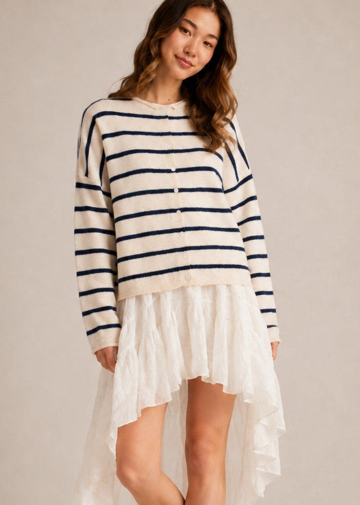 Model wearing the Things Between Piper Cardigan Cabana Stripe Natural Navy  in a relaxed standing outfit
