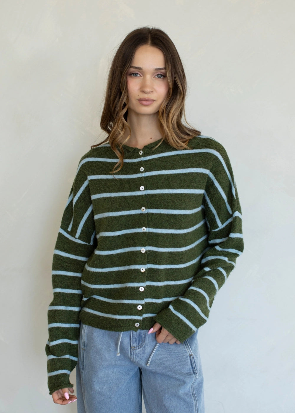 Front view of the Things Between Piper Cardigan Cabana Stripe Olive Blue with button-down front and light blue stripes