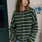 Model wearing the Hailey Button Down Cardigan in Cabana Stripe Olive-Blue with light blue stripes and relaxed jeans