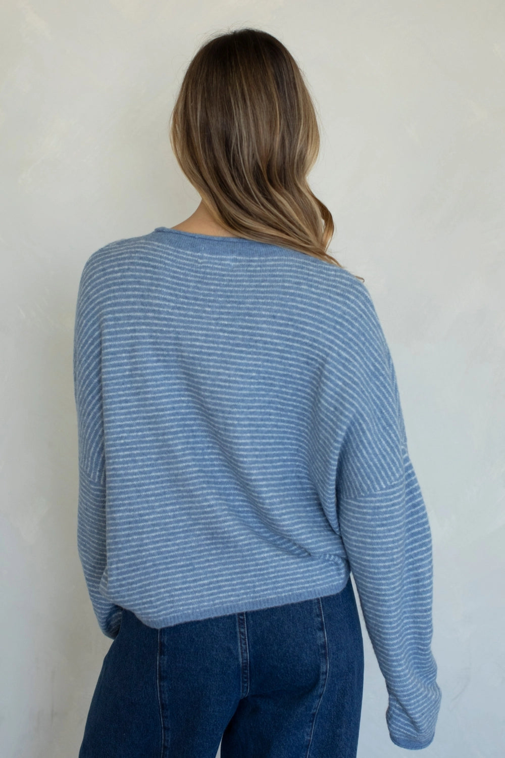 Back view of the Hailey Button Down Cardigan in a Dusty Blue pin-striped knit.