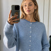 Lifestyle selfie of a model wearing the Hailey Dusty Blue pin-striped cardigan.