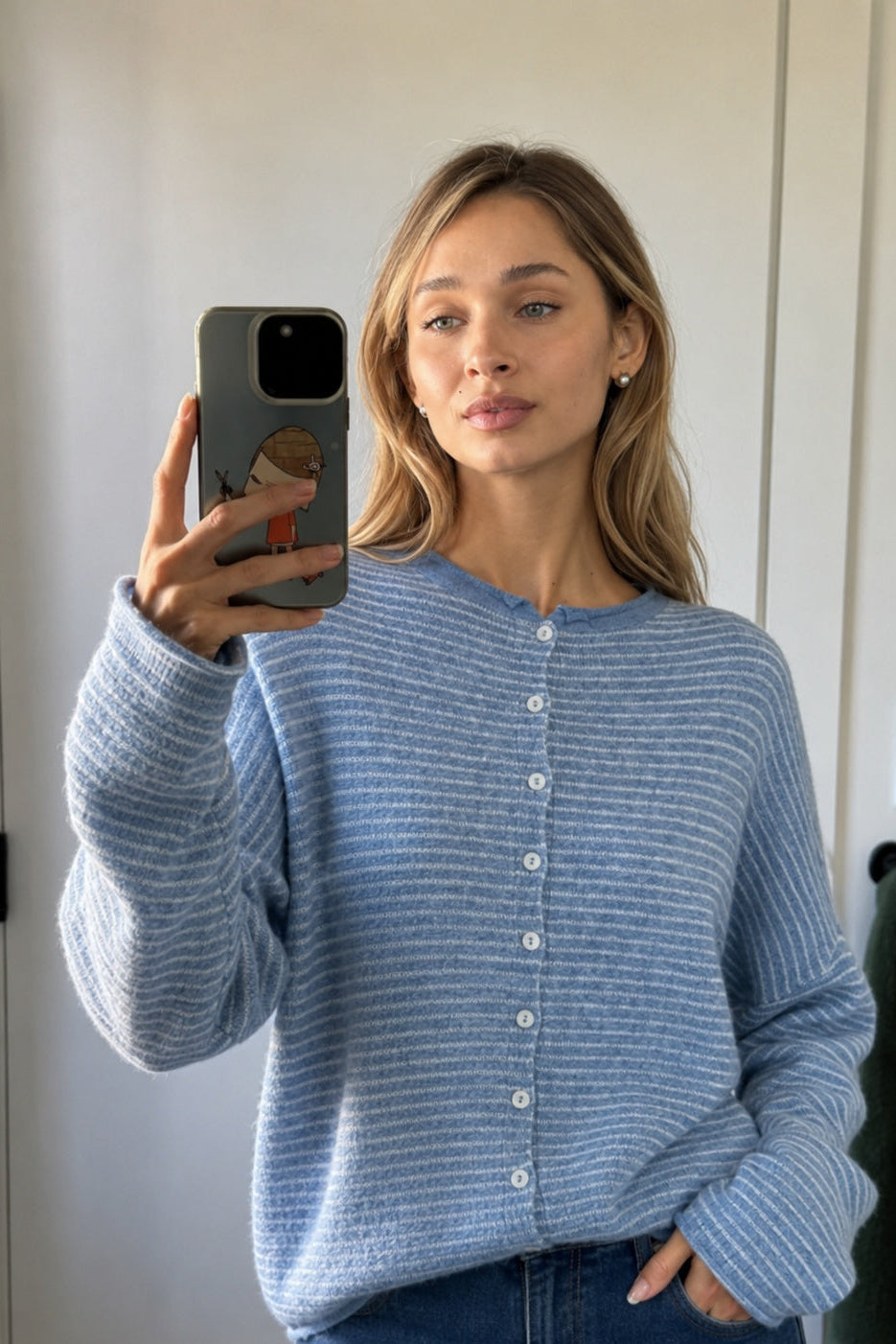 Lifestyle selfie of a model wearing the Hailey Dusty Blue pin-striped cardigan.