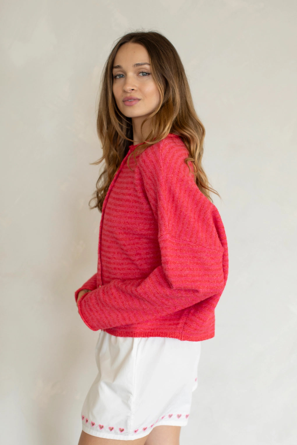 Woman wearing Hailey Button Down Cardigan in mini striped cherry red side view