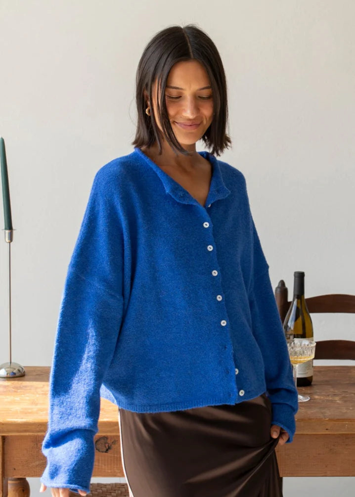 Woman wearing the blue Piper Cardigan (Hailey Button Down Cardigan) styled with skirt — cozy and chic everyday outfit.