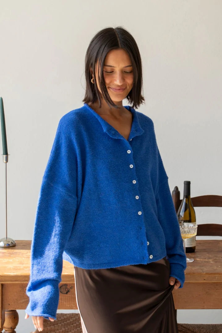 Woman wearing the blue Piper Cardigan (Hailey Button Down Cardigan) styled with skirt — cozy and chic everyday outfit.