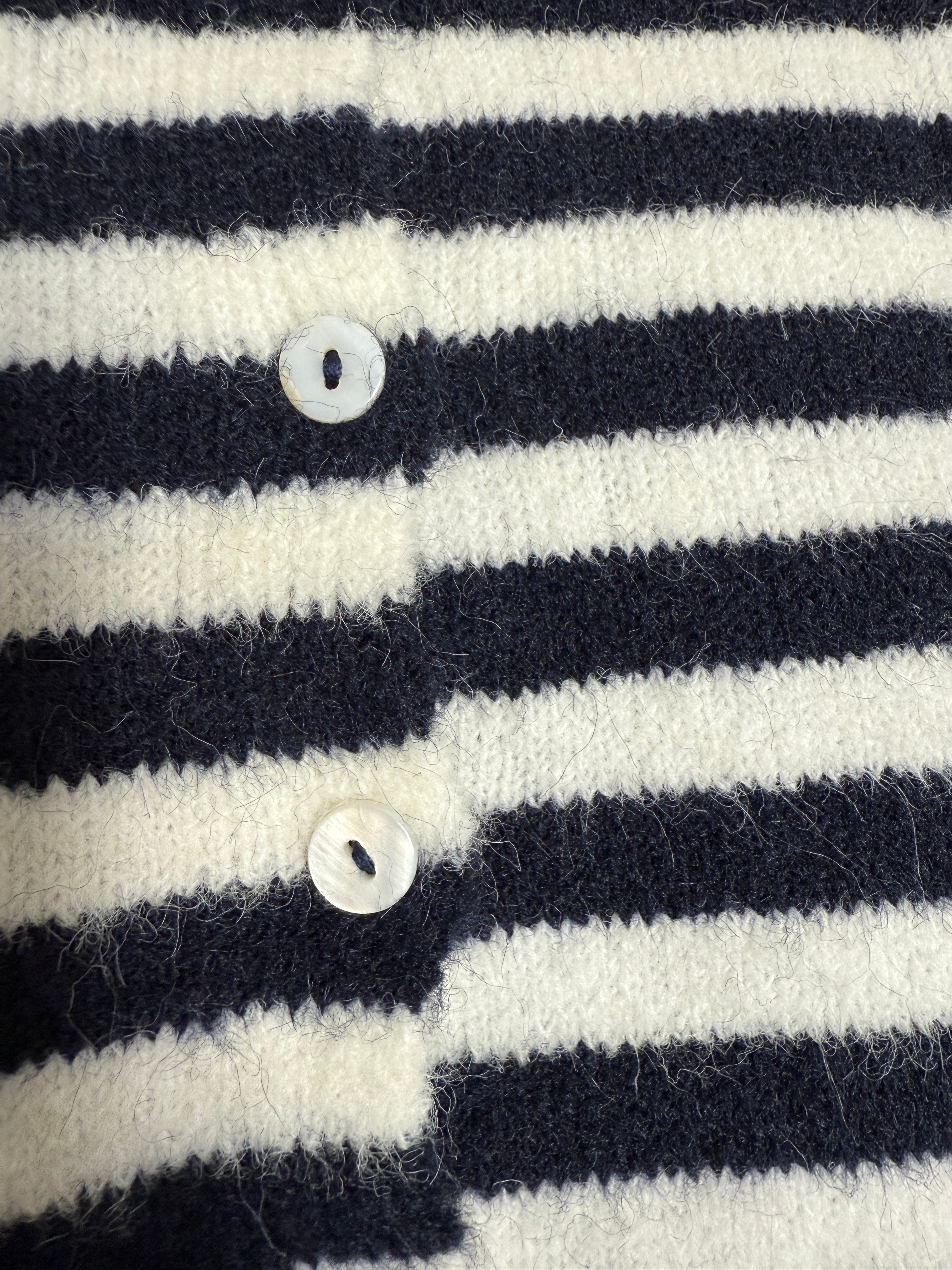 Close-up detail of the navy stripe knit texture and button finish
