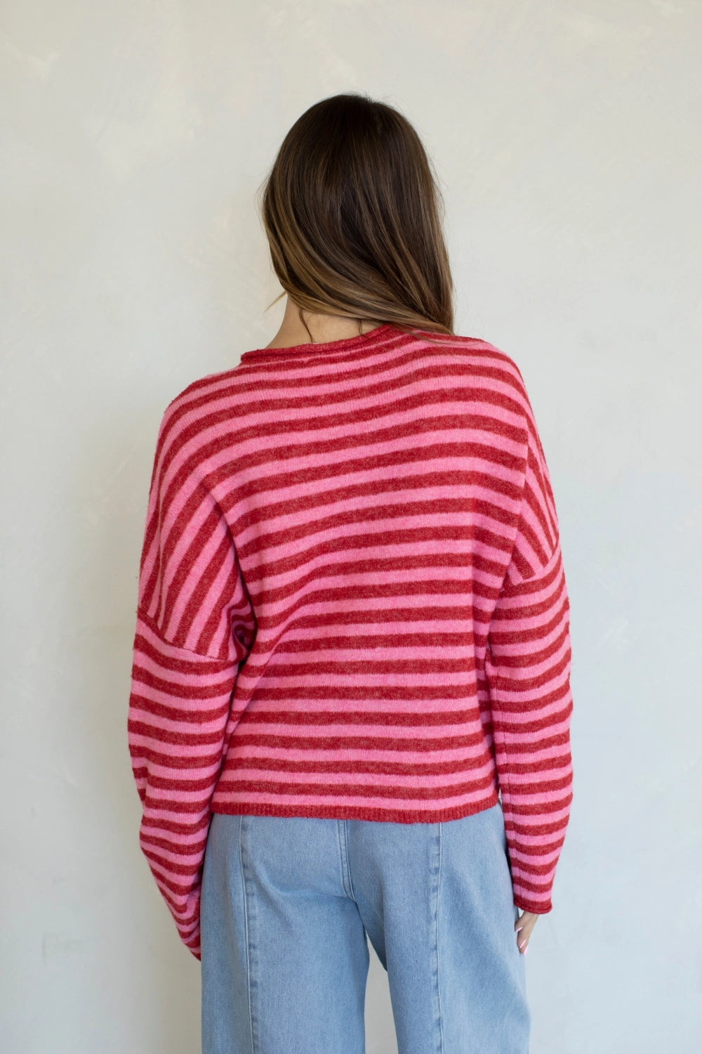 Back view of the Hailey Button Down Cardigan in a red and pink striped pattern.